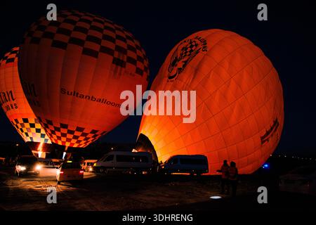 Kappadokien, Türkiye – 3. Oktober 2024: Heißluftballons schweben während einer Ballontour bei Sonnenaufgang über die felsige Landschaft Kappadokiens Stockfoto