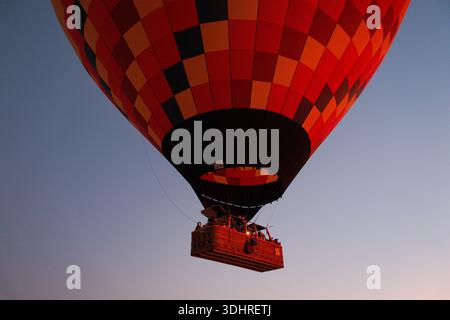 Kappadokien, Türkiye – 3. Oktober 2024: Heißluftballons schweben während einer Ballontour bei Sonnenaufgang über die felsige Landschaft Kappadokiens Stockfoto