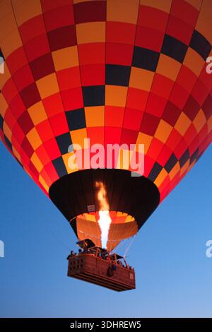 Kappadokien, Türkiye – 3. Oktober 2024: Heißluftballons schweben während einer Ballontour bei Sonnenaufgang über die felsige Landschaft Kappadokiens Stockfoto