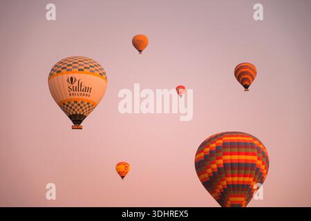 Kappadokien, Türkiye – 3. Oktober 2024: Heißluftballons schweben während einer Ballontour bei Sonnenaufgang über die felsige Landschaft Kappadokiens Stockfoto
