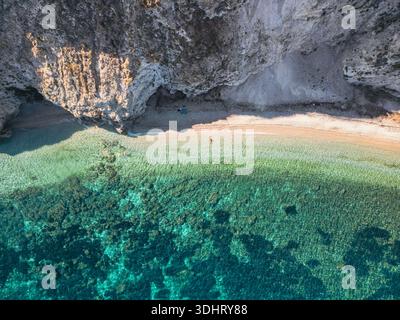 Aus der Vogelperspektive auf einen abgelegenen Strand mit klarem türkisfarbenem Wasser und felsigen Klippen. Elba Italien Stockfoto