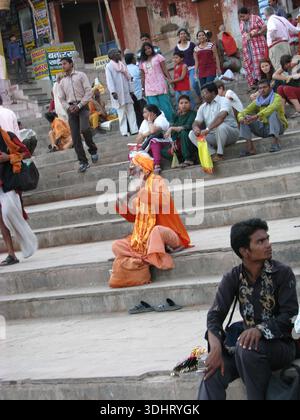 Menschen, die auf den Ghats in Varanasi, Indien, sitzen und ruhen Stockfoto