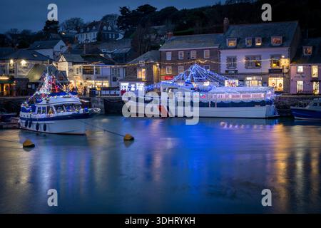 Vergnügungsboote einschließlich des Touristenbootes Jubille Queen, die nachts im Hafen von Padstow ankerten, mit Weihnachtslichtern dekoriert und mit fotografiert Stockfoto