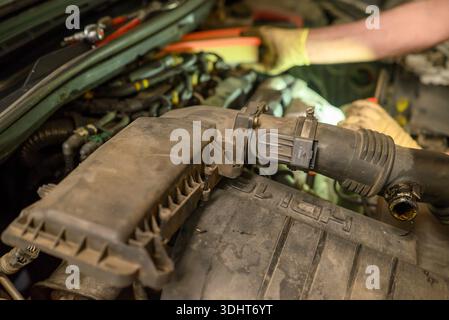 Mechaniker, der am schmutzigen Automotor arbeitet, das Konzept der Wartung Stockfoto