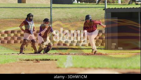 Trio auf dem Heimteller Softballfeld, Baserunner in braunem Jersey, Helm, Fänger mit Fäustling Stockfoto