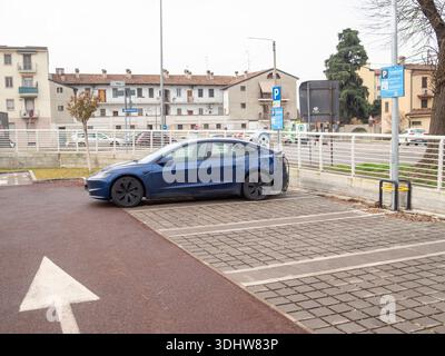 Cremona, Italien 9. Januar 2026 Blue Tesla Model 3 lädt im Freien an einer Station auf und symbolisiert sauberen Transport, umweltfreundliche Technologie und Nachhaltigkeit Stockfoto