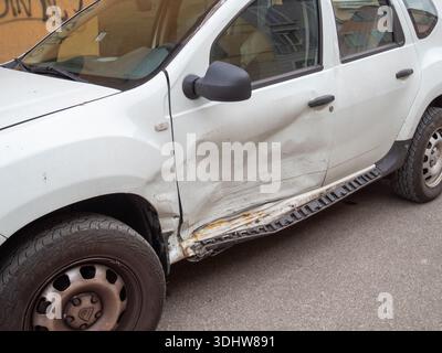 Cremona, Italien 9. Januar 2026 Weißer Dacia Duster SUV mit schweren Schäden an der Beifahrertür und am Kotflügel durch Kollision, Parken auf der Stadtstraße, kein pe Stockfoto