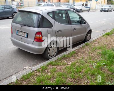 Cremona, Italien 9. Januar 2026 Silber Mercedes Benz Ein Kleinwagen der Klasse W168, der auf einer Stadtstraße mit einem flachen Vorderreifen geparkt ist, was auf ein Problem hinweist Stockfoto