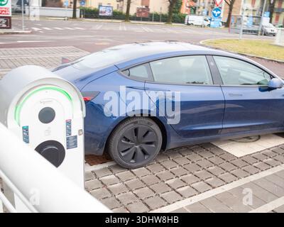 Cremona, Italien 9. Januar 2026 Blue Tesla Model 3 lädt im Freien an einer Station auf und symbolisiert sauberen Transport, umweltfreundliche Technologie und Nachhaltigkeit Stockfoto