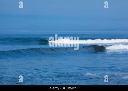 Ozeanwellen, die zum Ufer Rollen, weißes Wasser und Spritzen auf die Hammer. Stockfoto