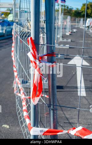 Metallzaun blockiert den Zugang mit rotem und weißem Warnband Stockfoto