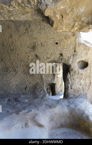 Raue Steinhöhlenwände mit Licht- und Schatteneffekten im Inneren, Höhlenstadt Uplistsikhe, Region Inner Kartli, Shida Kartli, Georgia Stockfoto