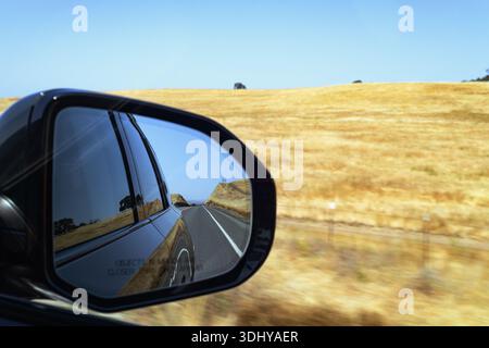 Blick in den Seitenspiegel eines Rivians während der Fahrt in Kalifornien. Stockfoto
