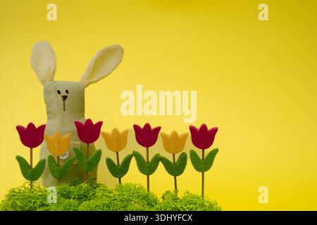 Osterhase mit bunten Tulpen auf Moos Stockfoto