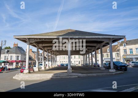 Unbekannter Ort - 13. April 2024: Das Bild zeigt das überdachte Marktgebäude mit der Aufschrift „C G des Remorqueurs“ auf der Vorderseite, gestützt von Säulen, umgeben von geparkten Autos und lokalen Unternehmen im Stadtzentrum. Stockfoto