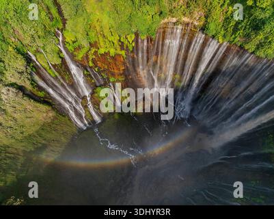 Blick von oben auf den Tumpak Sewu Wasserfall mit Regenbogen im üppigen tropischen Wald, Indonesien Stockfoto