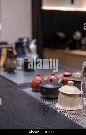 Traditionelle japanische Teezubereitungswerkzeuge auf der Theke, darunter Teetassen und Bambus-Matcha-Whiskys Stockfoto