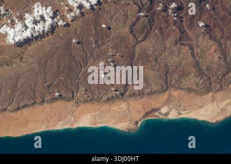 Südküste der Insel Socotra, die zum Jemen gehört. Socotra, lokal bekannt als Saqatri, ist eine jemenitische Insel im Indischen Ozean. Es liegt zwischen dem Golf von Aden, dem Guardafui-Kanal und dem Arabischen Meer, Ein Foto, das am 20. April 2023 von der Internationalen Raumstation aufgenommen wurde. Eine optimierte Version eines Originalbildes der NASA: Credit: NASA Stockfoto