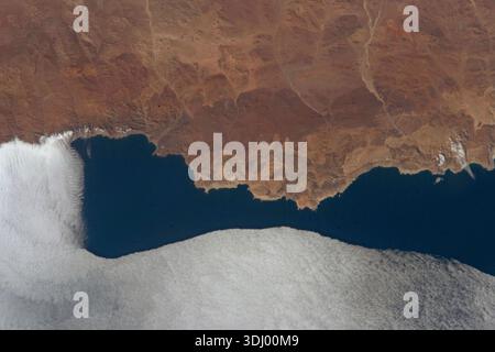 Die bergige Küste von Pan de Azucar, einem Nationalpark in Chile, wird von einer Wolkendecke getroffen, die sich vom Pazifischen Ozean aus bewegt, als die Internationale Raumstation 263 km über die Höhe ragte. Der Nationalpark Pan de Azœcar ist ein Nationalpark Chiles. Der Park erstreckt sich über die Grenze zwischen der Region Antofagasta und der Region Atacama. Sein Name, Parque Nacional Pan de Azœcar, bedeutet „Zuckerhut-Nationalpark“. Ein Foto von der Internationalen Raumstation am 16. September 2023. Eine optimierte Version eines Originalbildes der NASA: Credit NASA/AMogensen Stockfoto