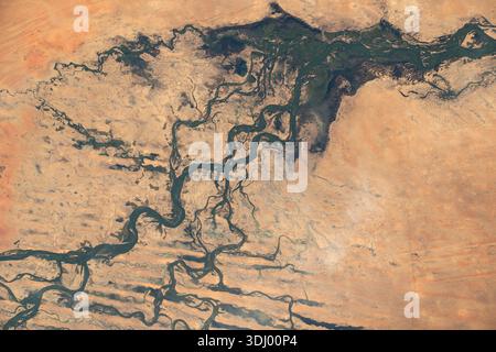 Der Niger, nahe der Stadt Timbuktu in der afrikanischen Nation Mali, ist von der Internationalen Raumstation aus in einer Umlaufbahn von 258 km zu sehen. Ein Foto von der Internationalen Raumstation am 4. Dezember 2023. Der Niger ist Westafrikas Hauptfluss, der drittlängste Fluss des Kontinents (nach dem Nil und dem Kongo), der etwa 4200 km in einem markanten Bogen von Guinea über Mali, Niger und Nigeria bis zum Golf von Guinea (Atlantik) fließt Stockfoto