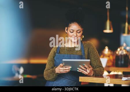 Tablet, Gastfreundschaft und Frau im Restaurant, Lesen von Rezensionen und digitale App für Menüoptionen. Unternehmer, Geschäftsinhaber und Person in Café, Technik und Stockfoto