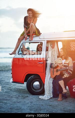 Sonnenuntergang, Gitarre und Leute mit dem Wohnwagen am Strand für Urlaub, Reise oder Wochenendausflug zusammen mit Musik. Outdoor, Sommer und Freunde mit Schnur Stockfoto