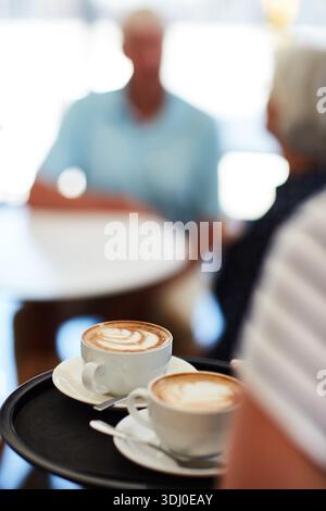 Hände, Person und Tablett mit Kaffee im Café für Kundenbestellung, Kundenservice und Gastfreundschaft. Nahaufnahme, Angestellter und Servieren von Getränken mit Pärchen bei Stockfoto