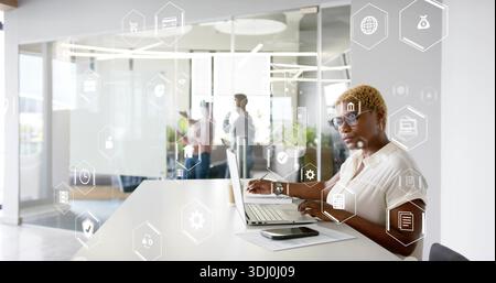 Arbeitende Frau mit Laptop an der Bürotheke mit Notebook, mit Bluse und Brille, Kopierraum Stockfoto