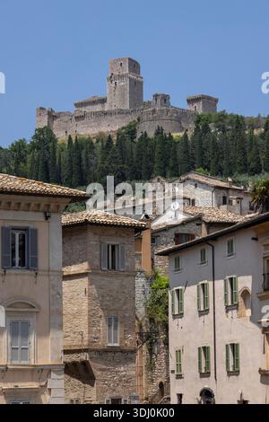 Assisi, Italien - 12. Juni 2025: Blick auf die Burg Rocca Maggiore, Ruinen der mittelalterlichen Festung auf einem Hügel über der Stadt. Alte Steinhäuser Stockfoto
