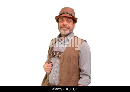 Ein Mann im Alter von 50 55 Jahren mit traditioneller Tiroler Weste und Hut posiert vor weißem Hintergrund Stockfoto