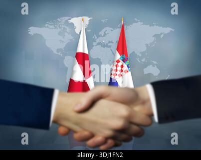 Zwei Menschen schütteln sich die Hand vor kroatischen und grönländischen Flaggen Stockfoto