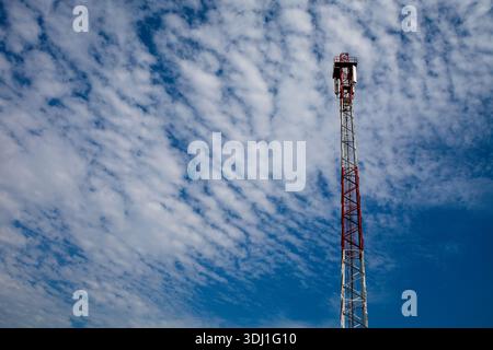 Der Kommunikationsturm Erreicht Den Blauen Himmel Mit Wolken, Industriestruktur Gegen Klares Wetter Stockfoto