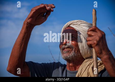 Älterer Mann Mit Turban Hält Personal Draußen Unter Klarem Blauen Himmel Mit Verwittertem Ausdruck Stockfoto