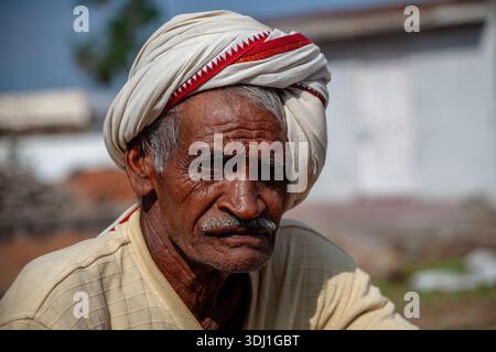 Älterer Mann, Der Im Freien Turban Trägt, Mit Reflektierendem Ausdruck In Traditioneller Kleidung Stockfoto