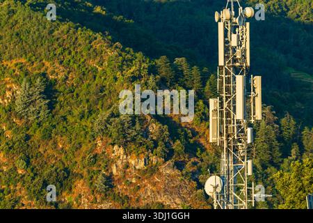 Telekommunikationsturm steht vor einer Berglandschaft und gewährleistet die Abdeckung des drahtlosen Netzwerks Stockfoto