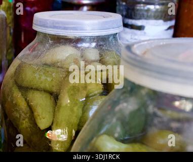 Bio fermentierte Gurken in einem Glas auf einem rustikalen Küchenhintergrund. Gesunde probiotische Nahrung für die Winterlagerung. Stockfoto