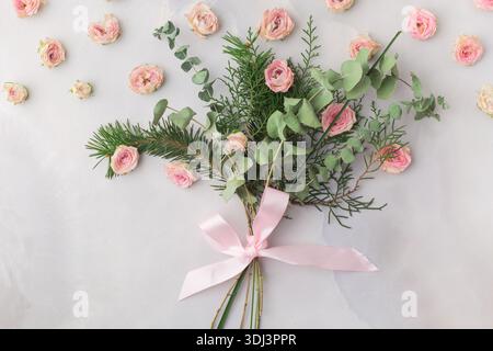 Weihnachtsstrauß mit Rosenblättern und Satinband – warme romantische Ästhetik. Hochwertige Fotos Stockfoto