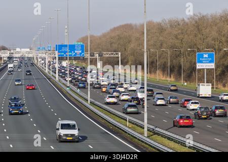 Luftaufnahme des starken Verkehrs am Autobahnkreuz Oudenrijn an der Autobahn A2, Niederlande. Mehrspurige Autobahn mit Autos und blauen Straßenschildern. Stockfoto