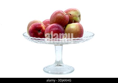 Reife Gartenäpfel in einer transparenten Obstschale. Isoliertes Objekt für gesunde Ernährung, Ernährung, Ernte und gemütliche Küche Innenausstattung Themen. Stockfoto