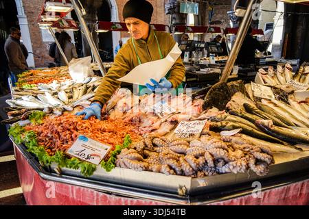 Rialto Fischmarkt Venedig, Italien, mit frischem Fisch und Meeresfrüchten und Verkäufern am Stand Stockfoto