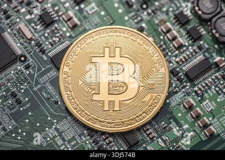 Bitcoin Goldmünze auf grüner Computerplatine Stockfoto