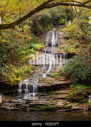 Ein kaskadenförmiger Wasserfall fließt durch einen friedlichen, moosigen Herbstwald tief in den Smoky Mountains. Stockfoto