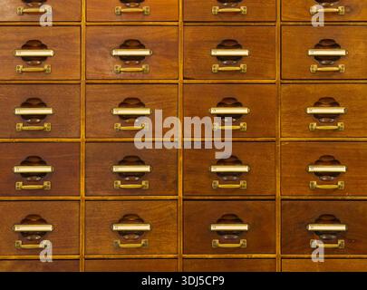 Nahansicht des antiken Aktenschranks aus Holz mit mehreren Schubladen und Messingbeschlägen Stockfoto