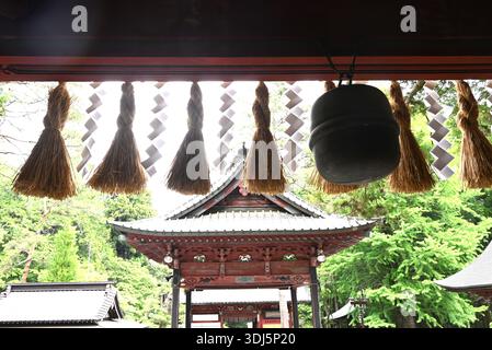 An japanischen Schreinen sind „Shide“ zickzackförmige Papierschmuck, die an Seilen der Shimenawa befestigt sind und zur Abgrenzung heiliger Räume verwendet werden. Stockfoto