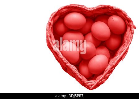 Hühnereier aus Freilandhaltung in einem herzförmigen Korb aus Wasserhyazinthen mit rotem Farbton. Gesund ernährendes Herzkonzept. Stockfoto