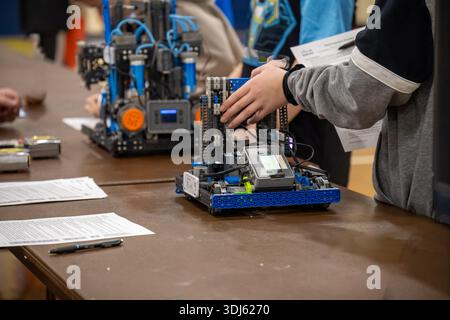 Die Schüler nehmen an einem Robotik-Wettbewerb Teil und präsentieren ihre Projekte an einem Samstagnachmittag in einem Fitnessstudio Stockfoto