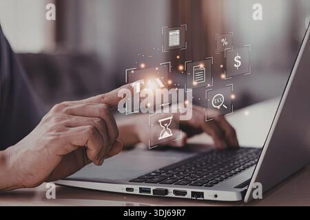 Eine Person, die mit einem Laptop interagiert und verschiedene Geschäfts- und Technologiesymbole anzeigt, die Konzepte wie Finanzen, Zeitmanagement und Daten darstellen Stockfoto