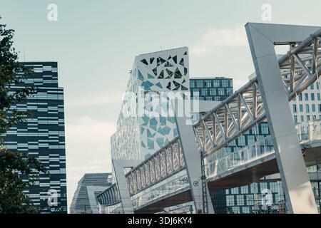 Moderne Architektur im Barcode-Projektviertel mit dem Deloitte-Gebäude und der Akrobaten-Fußgängerbrücke bei Sonnenuntergang, Bjørvika, Oslo. Stockfoto