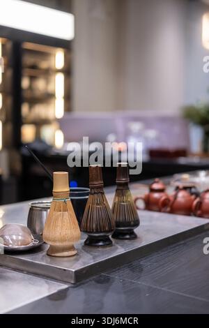 Traditionelle japanische Teezubereitungswerkzeuge auf der Theke, darunter Bambus-Matcha-Whiskys und Teebecher Stockfoto