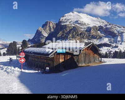 Hütte an der Spitze der Florian-Sessellift auf der Seiser Alm mit Beginn der roten Abfahrt 34 und Blick auf Sasso Piatto (Plattkofel) dahinter. Stockfoto
